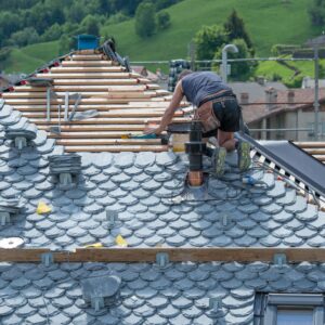 Contractor installing slate roof tiles correctly