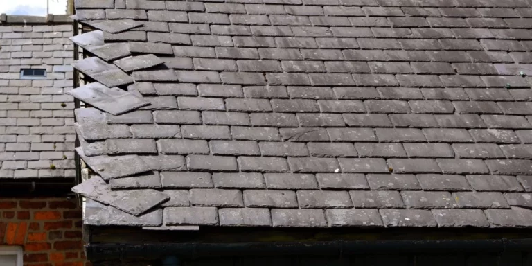 Slate shingles sliding and separating on historic roof requiring specialized professional repair expertise